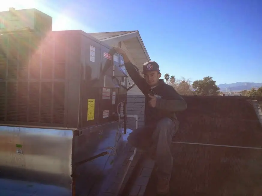 HVAC technician performing AC Tune-Up on a rooftop unit in Whitemarsh Island